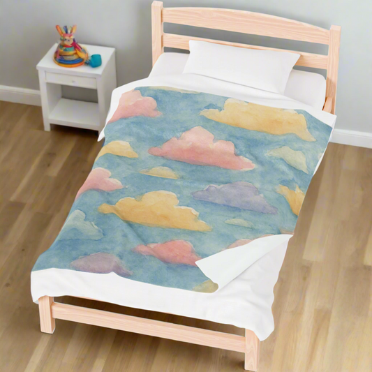 Watercolor pastel cloud plush blanket on a child's bed