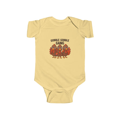 Yellow baby onesie with 'Gobble Gobble Gang' text and turkey graphics on a white background