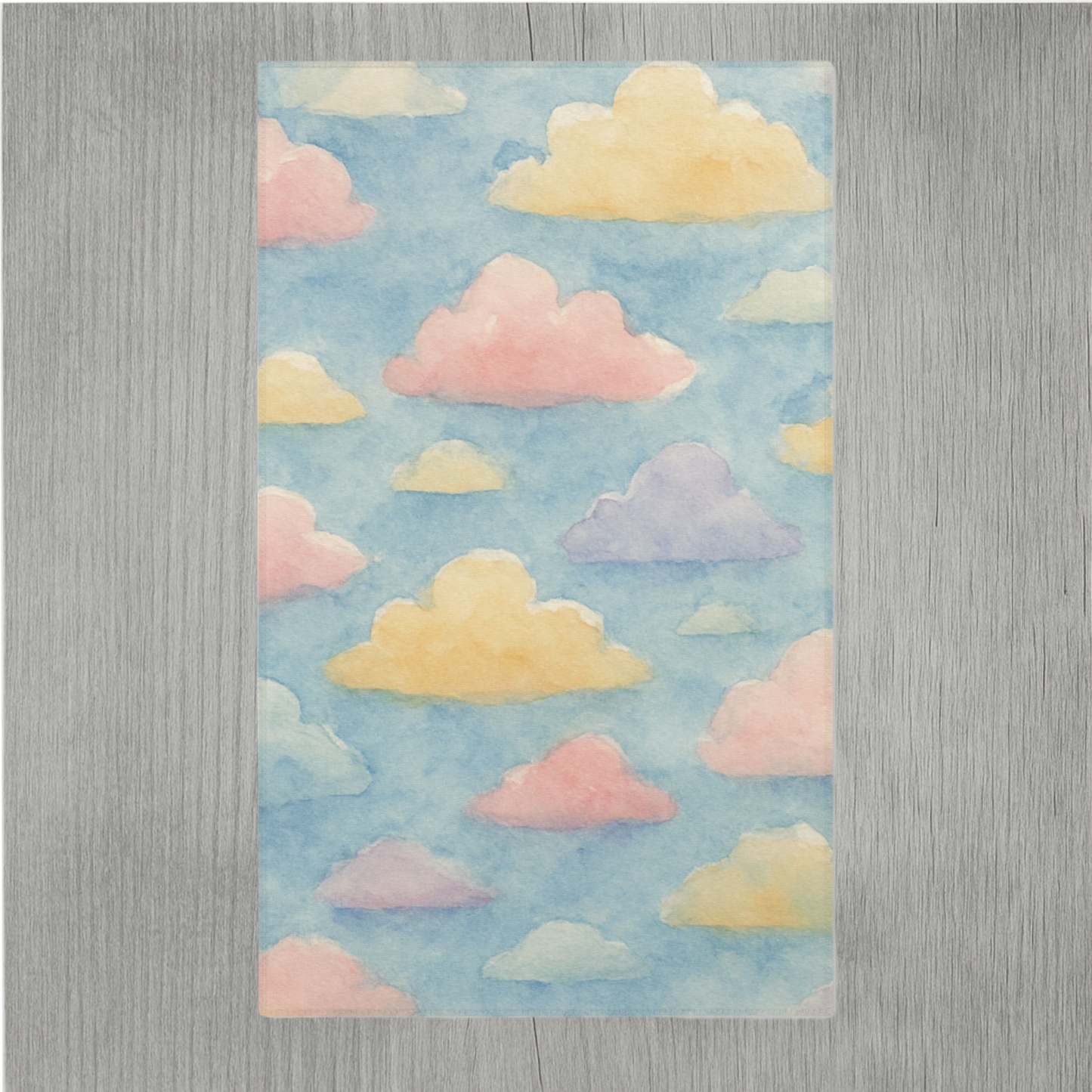 Watercolor nursery rug featuring dreamy clouds and hemmed edges for added durability