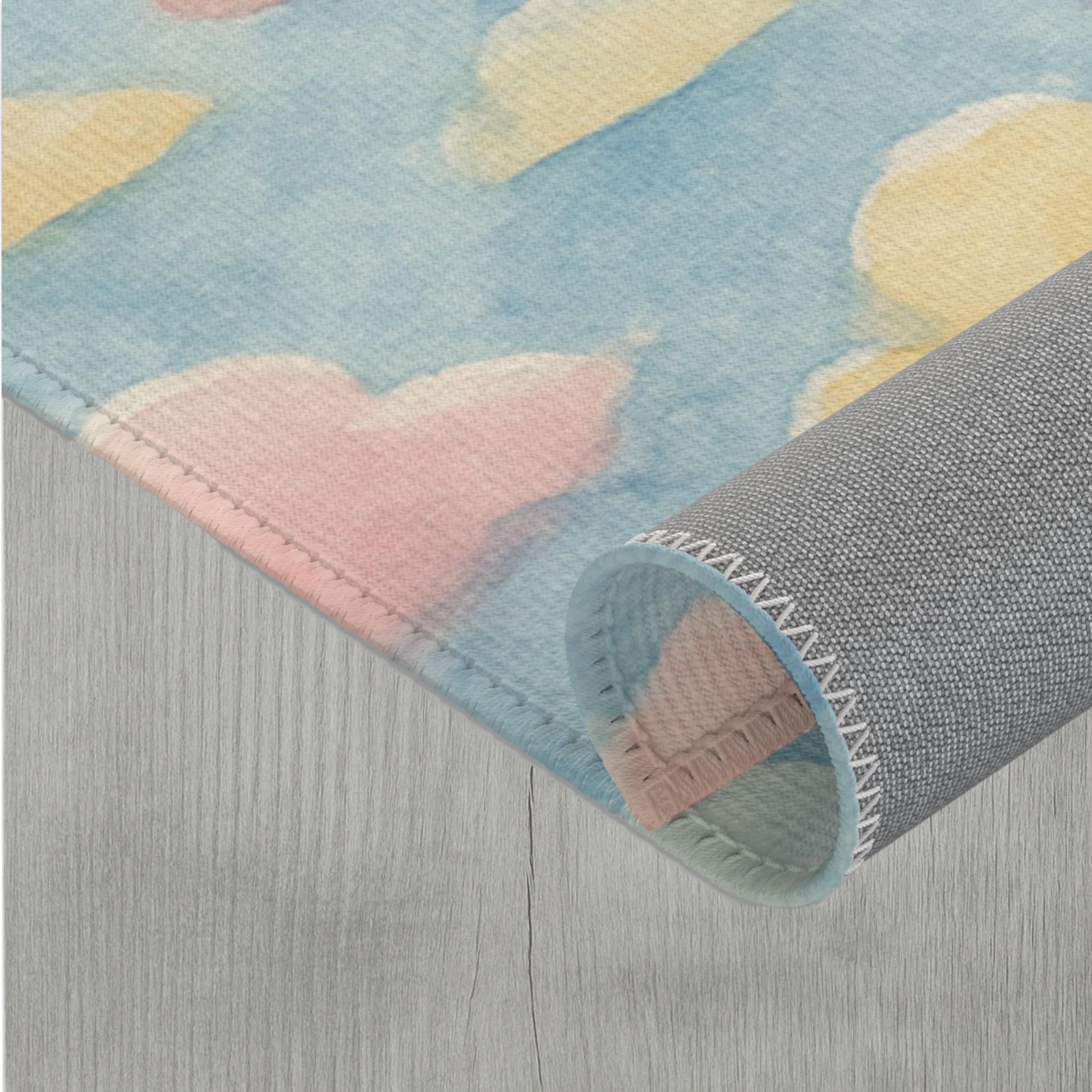 Pastel cloud area rug with soft watercolor design and vibrant rainbow colors on a blue background