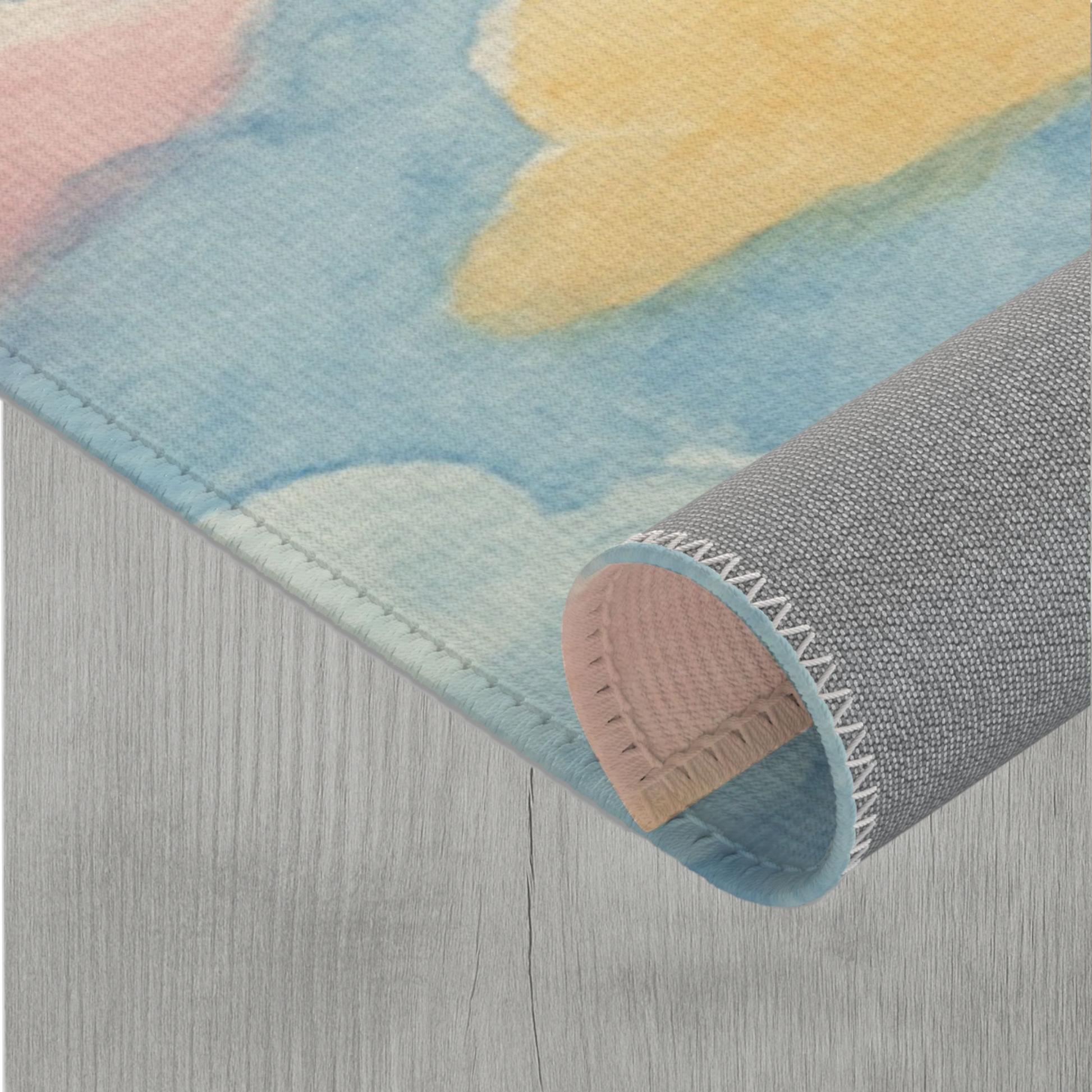 Modern cloud-themed rug with non-slip grey underside and colorful watercolor print